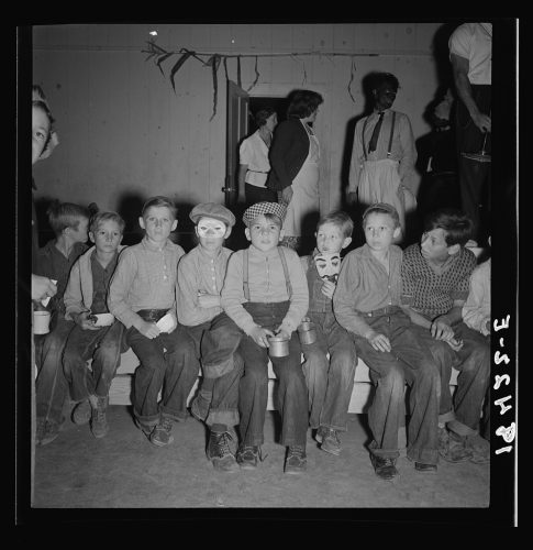 Niños en una fiesta de Halloween, esperando la señal para tomar un refrigerio. 