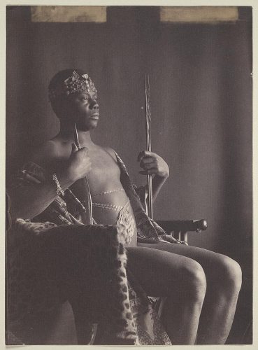 Joven con traje africano en un trono. 